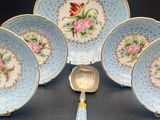 six pieces of blue and white china with pink flowers on them
