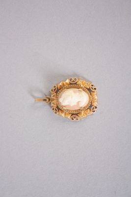 une image représentant une broche en or ornée d'un coquillage au centre