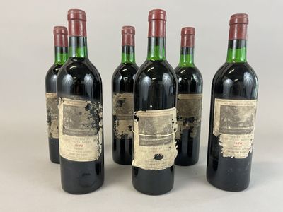 quatre bouteilles de vin sont alignées sur une surface blanche