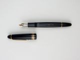 a close up of a pen and a ballpoint pen on a white surface