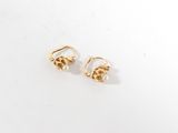 une paire de boucles d'oreilles en or sur fond blanc