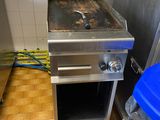 une image d'une cuisine avec une cuisinière et une poubelle