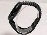 a black apple watch on a clear stand on a white surface