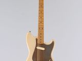 an electric guitar hanging from a string on a gray background