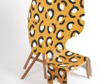 yellow and black patterned chair with wooden legs on white background