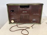 an old radio sitting on top of a table next to a cord
