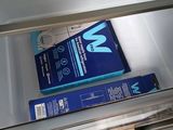 a box of toothpaste sitting inside of an open refrigerator