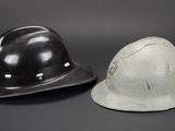 two helmets are sitting side by side on a black background