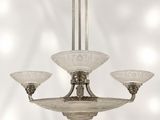 un lustre muni de trois abat-jours en verre suspendu au plafond
