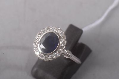 an image of a ring with a blue stone surrounded by diamonds
