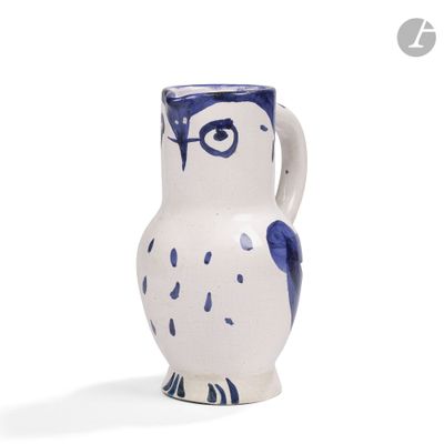 un vase bleu et blanc en forme de chouette posé sur un fond blanc
