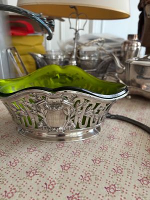 un bol en verre vert posé sur une table à côté d'une lampe