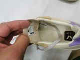 a person holding a shoe that has a tag on it