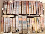 une boîte en carton ouverte, remplie d'une multitude de vieux livres, posée sur une table
