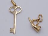 a gold key and a gold bell on a white surface