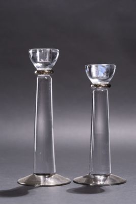 une paire de bougeoirs en verre transparent posés sur une table