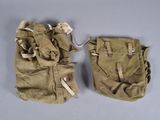 pair of old military pouchs on a table with one open and the other closed