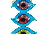 a sculpture of three different colored eyes on top of a wooden table