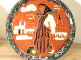 une assiette sur laquelle est représentée une femme, posée sur une table