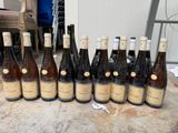 bottles of wine are lined up on a table in front of a chair