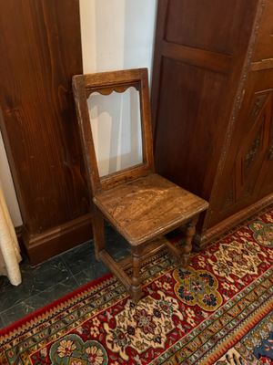 une chaise en bois posée devant une armoire en bois