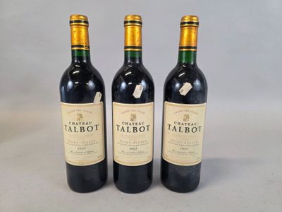 three bottles of red wine sitting next to each other on a table