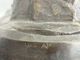 bronze statue of a woman with a hat on her head