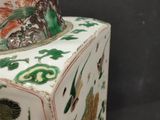 a vase that has a bird on top of it