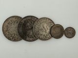 several old coins are arranged in a row on a white surface