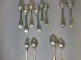 un grand nombre de cuillères et de fourchettes en argent disposées sur une table