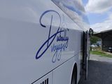 a large white bus parked next to a building