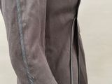 the woman is wearing a gray jacket and black pants