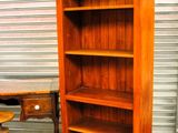 a wooden bookcase that is next to a table