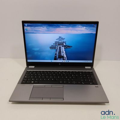 un ordinateur portable posé sur une table, avec une station d'accueil en arrière-plan