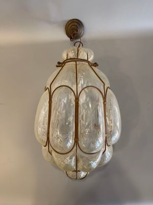 un luminaire en verre suspendu au plafond d'une pièce