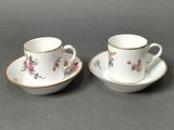 a pair of coffee cups and saucers with floral designs