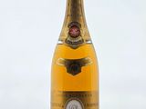 une bouteille de champagne posée sur une table près d'un mur blanc