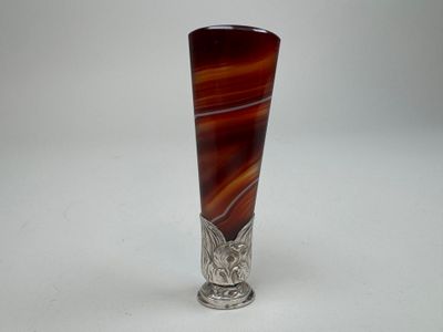 an image of a silver vase with a brown and red swirl design