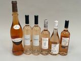 plusieurs bouteilles de vin posées les unes à côté des autres sur une surface blanche
