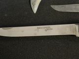 a knife that is sitting next to a knife on a table