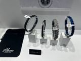 trois bracelets et un sac sont posés sur une table, à côté d'un sac noir