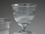 two glass vases sitting on top of a white pedestal