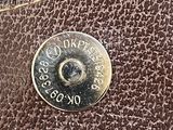 brown leather wallet with a coin on the front of it