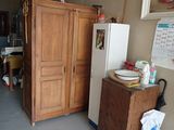 a refrigerator and a cabinet in a room with a lot of clutter on the floor