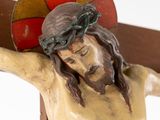 a statue of jesus on a wooden cross with a red and yellow background