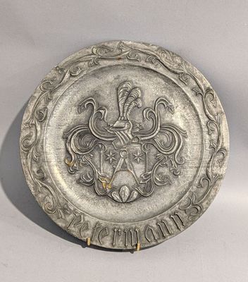 un vieux plat en argent orné d'un blason et d'une couronne