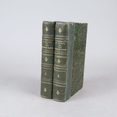 deux livres verts posés l'un sur l'autre sur une surface blanche