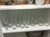 de nombreux verres et assiettes sur une étagère dans la cuisine