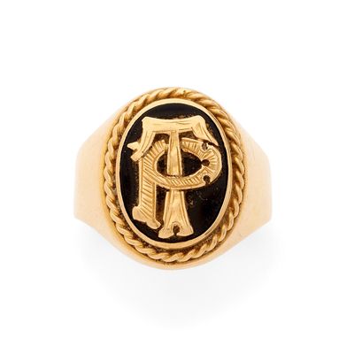 une image représentant une bague en or ornée d'un monogramme en noir et blanc