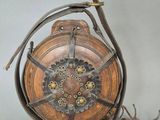 a metal and wood case with a clock inside of it